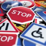 Znaki drogowe, w tym znak STOP, zwężenie jezdni lewostronne,